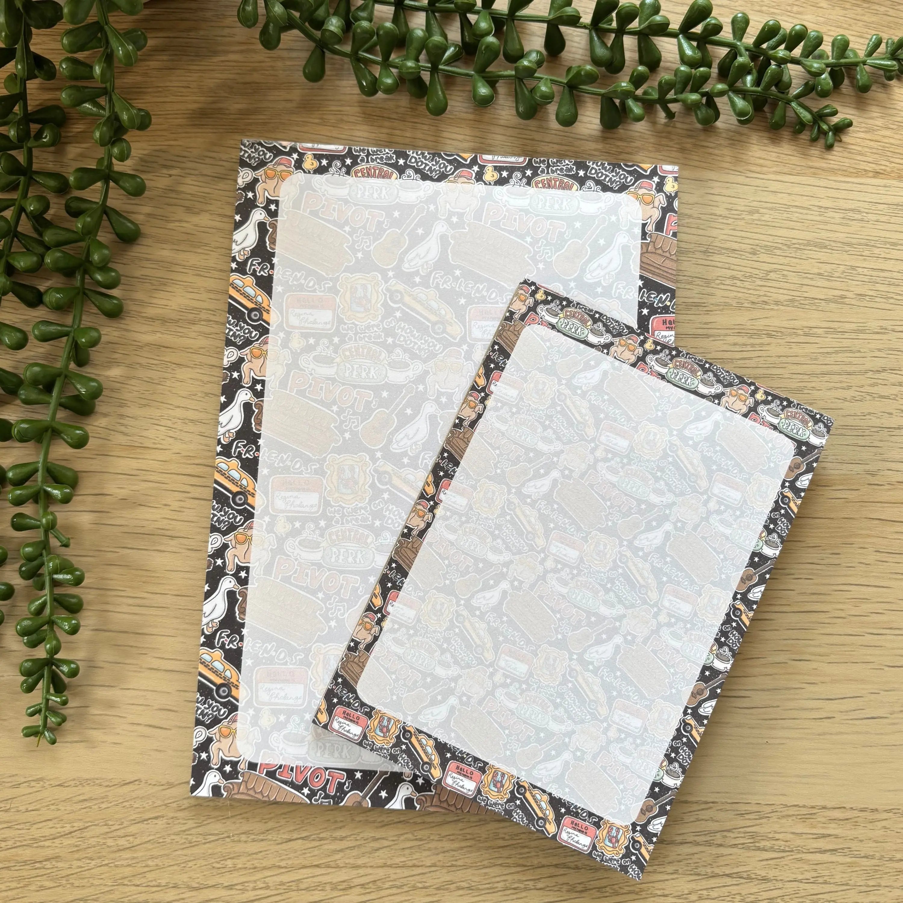 Two Pivot! Notepads, one large and one small, with a playful, minimalist pattern border featuring swirls and abstract shapes .