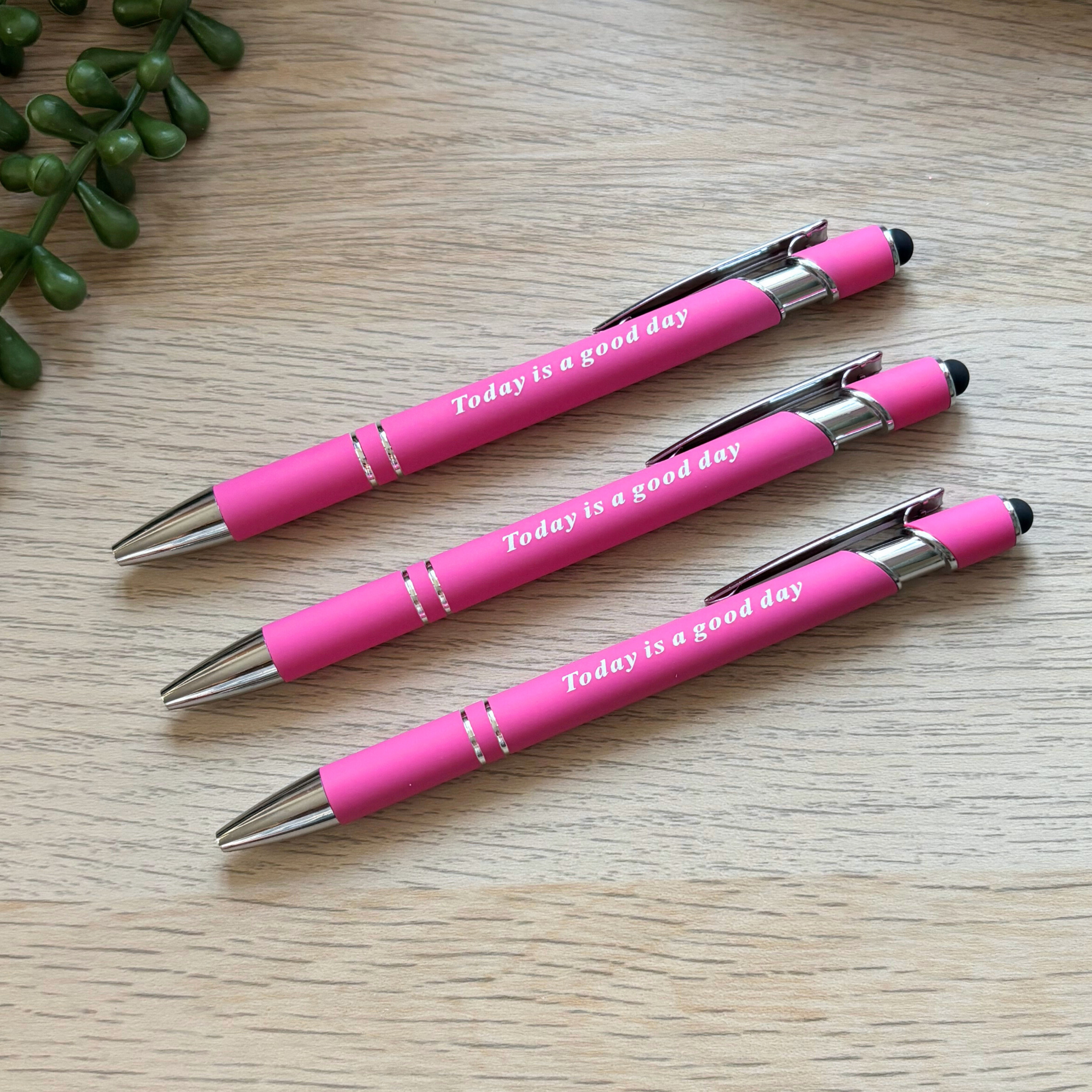 Bright pink metal pens with silver tips and clips, each printed with "Today is a good day" in white text.