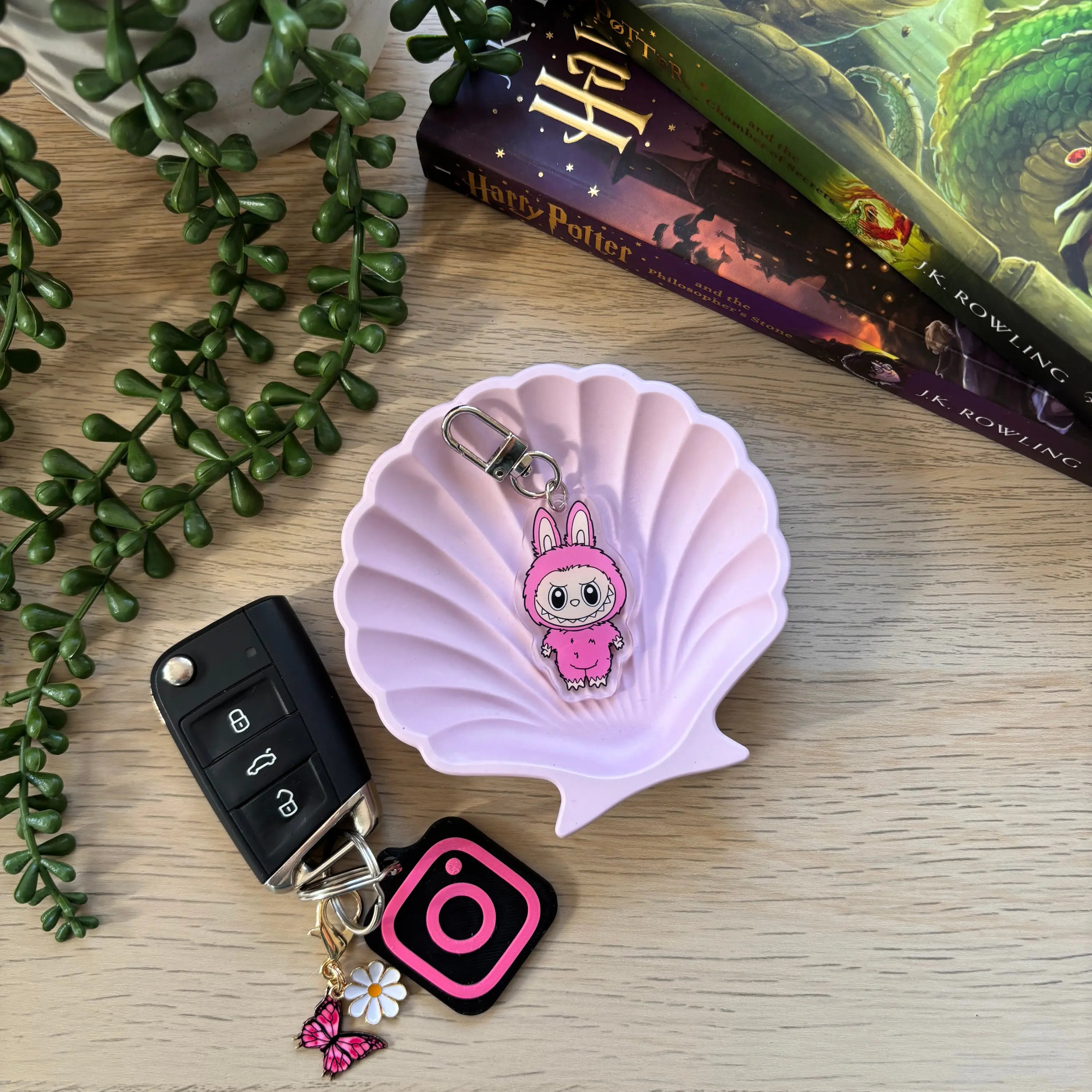 Pink keyring featuring a cute character in a bunny suit on a pink scallop shell dish.