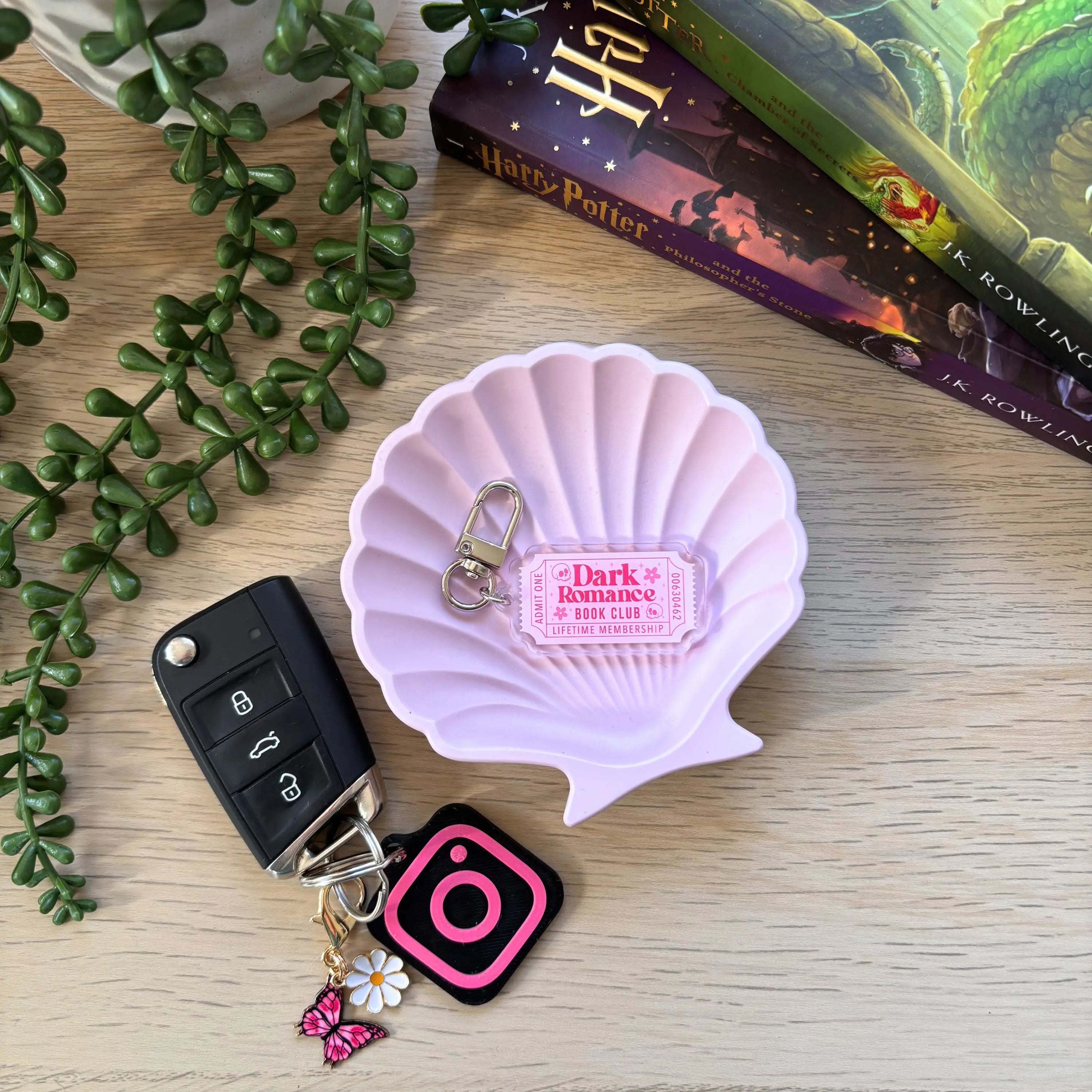 Pink shell-shaped keyring with "Dark Romance Bookish Ticket" text and gold lobster clasp.