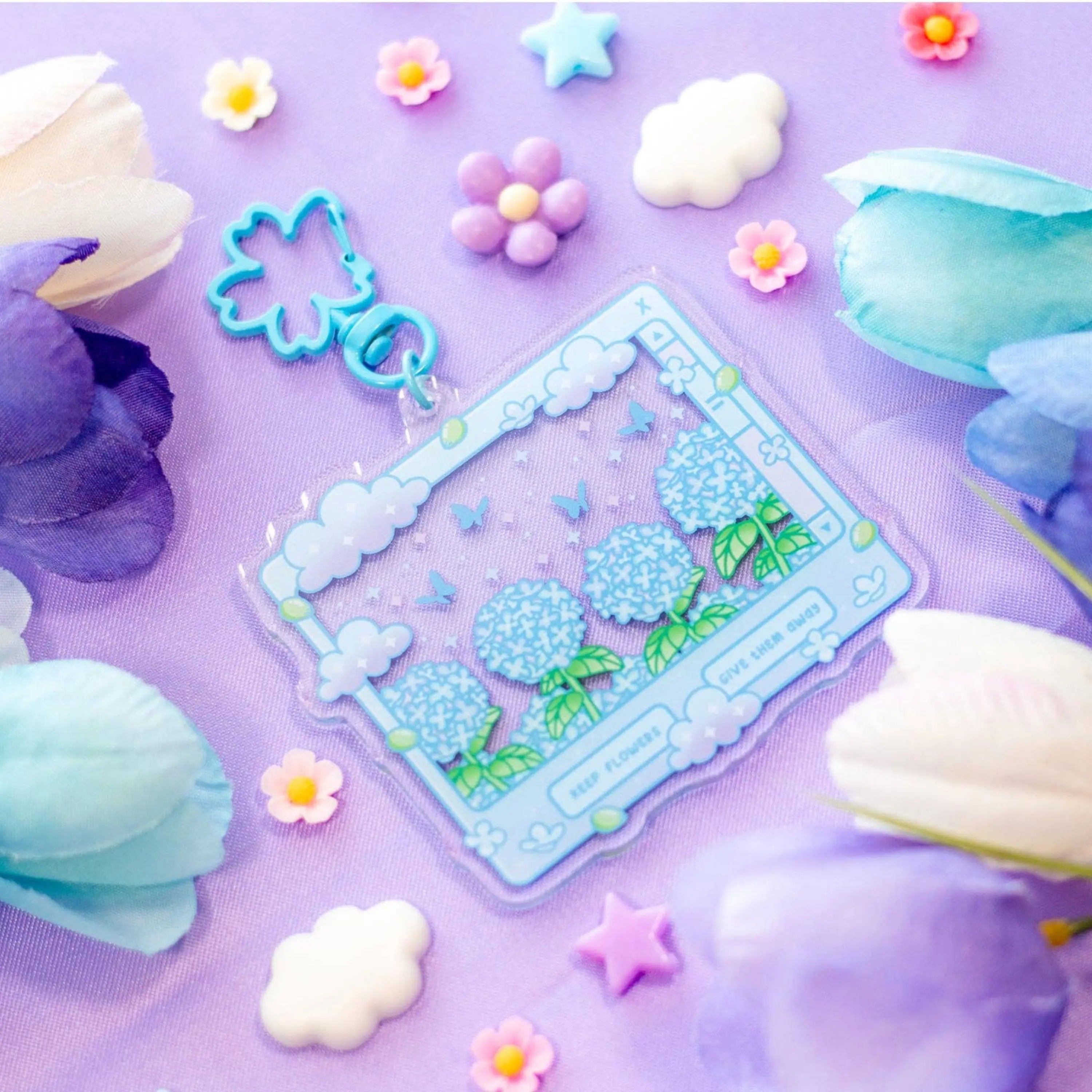 Decorative clear keyring set with floral design on a purple background with flowers and clouds.