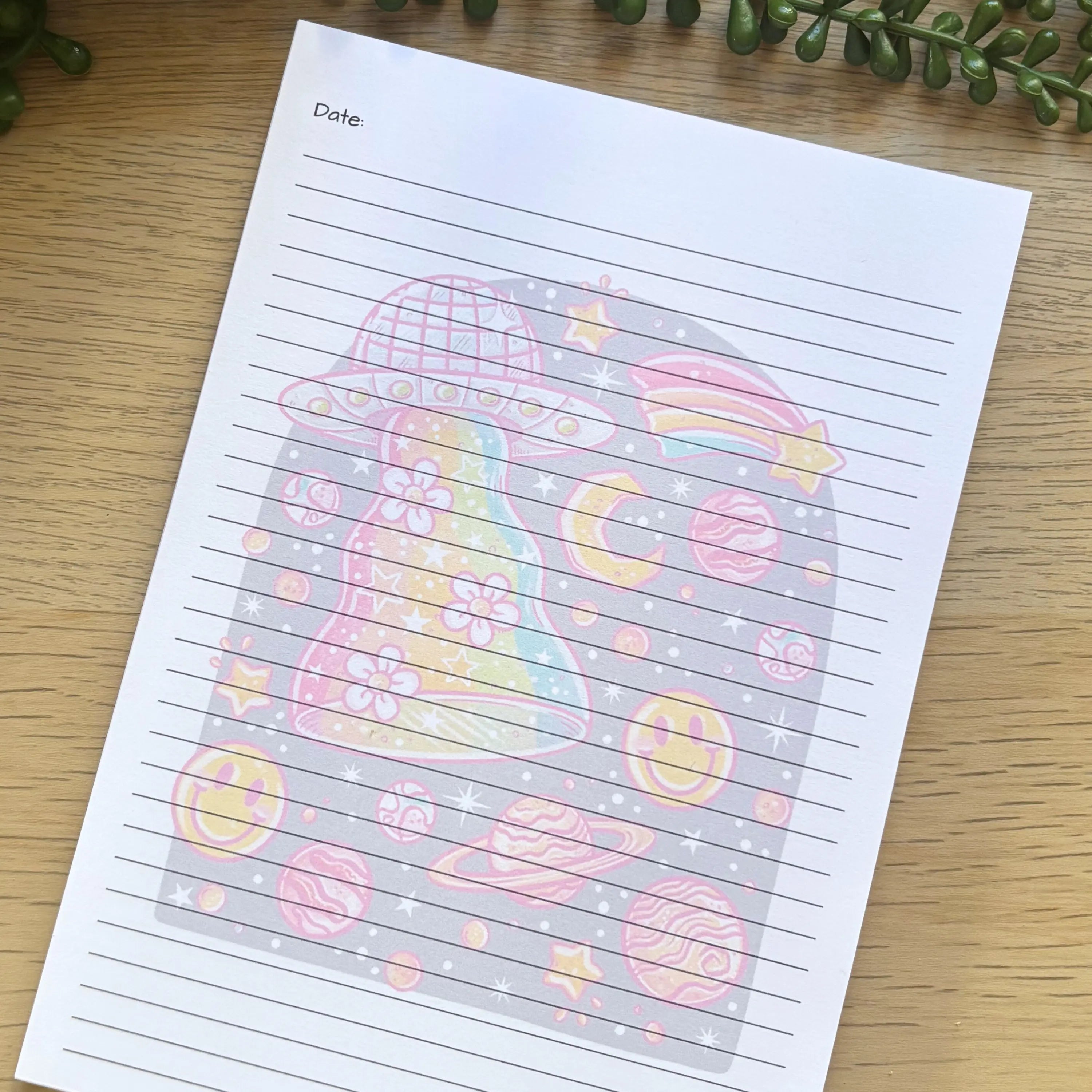 A5 lined notepad with colorful UFO and space-themed illustrations on white paper.
