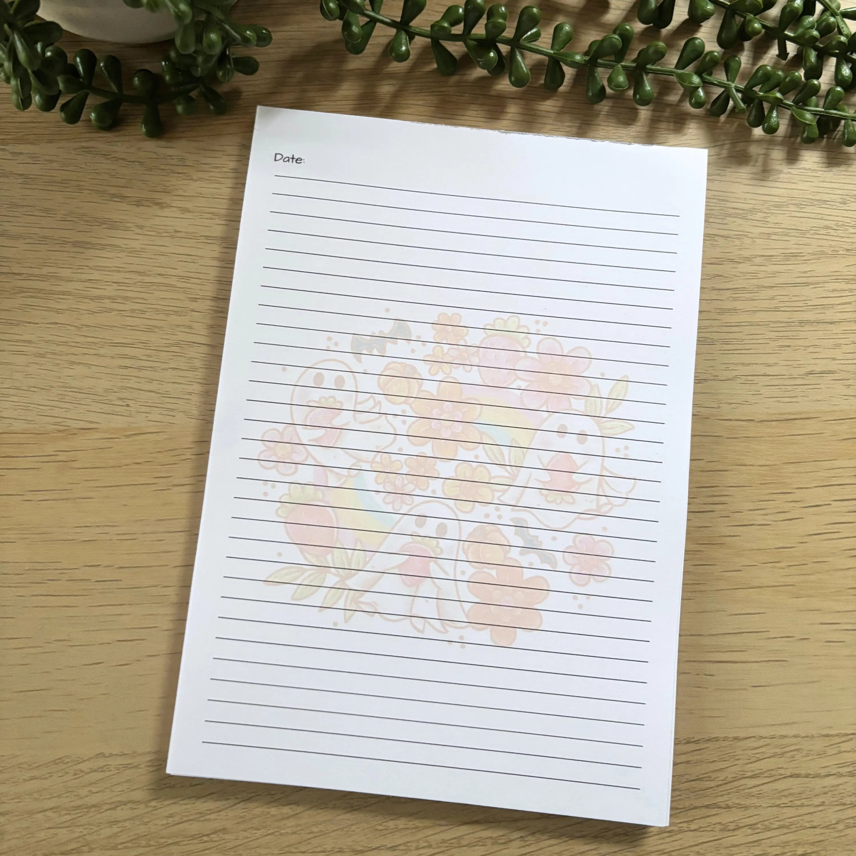 A5 notepad with lined pages and a subtle pastel strawberry ghost pattern in the center.