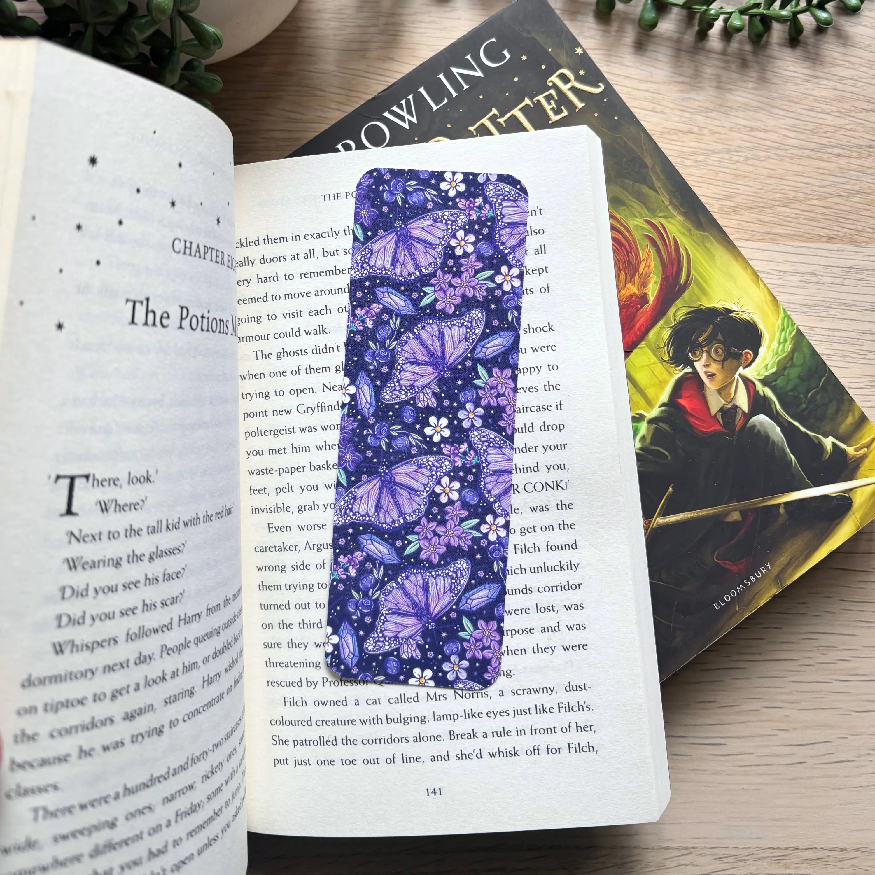 Purple bookmark with vibrant butterfly pattern resting in an open book.