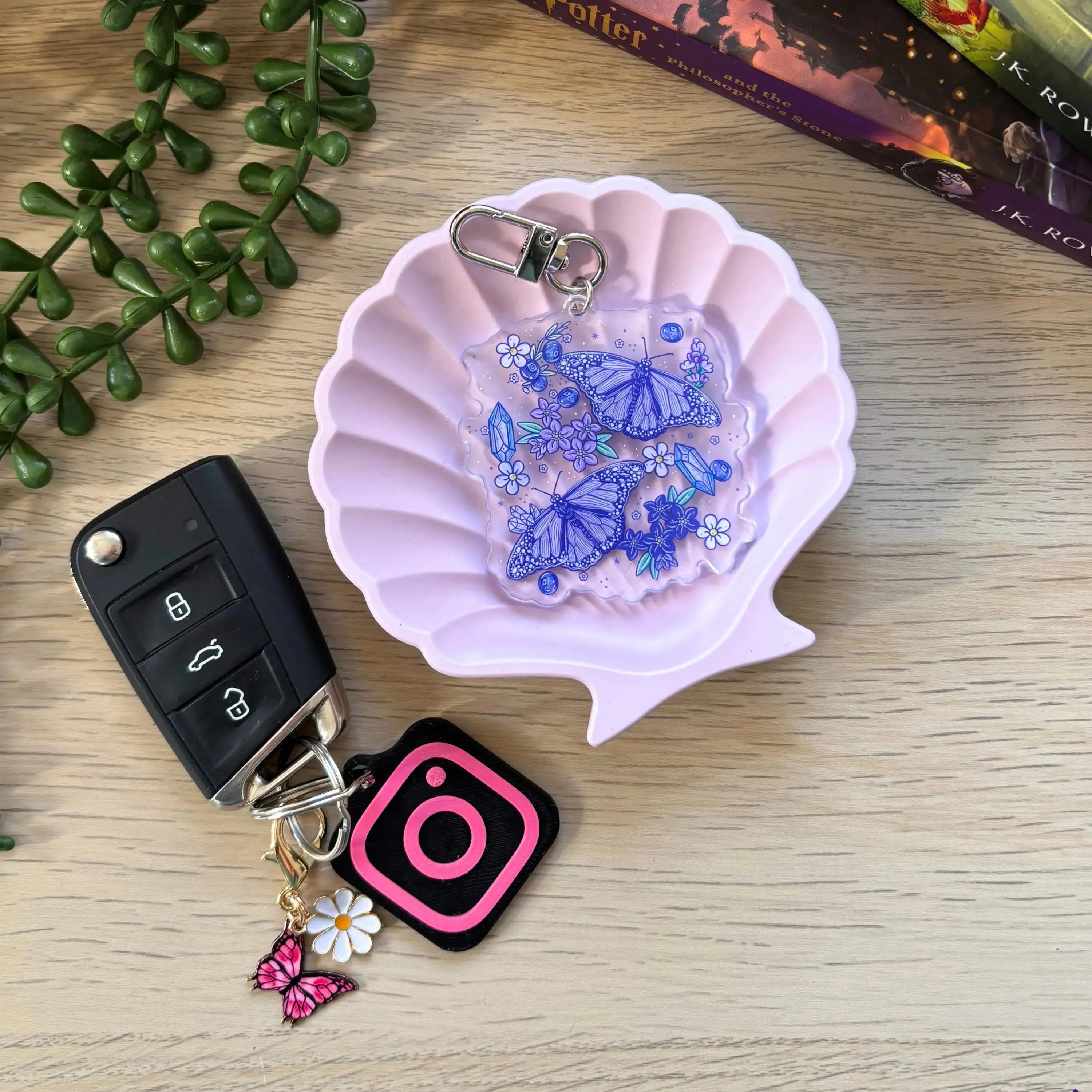 Purple keyring with blue butterfly charms and small beads on a silver chain attached to a key fob and pink butterfly charm.