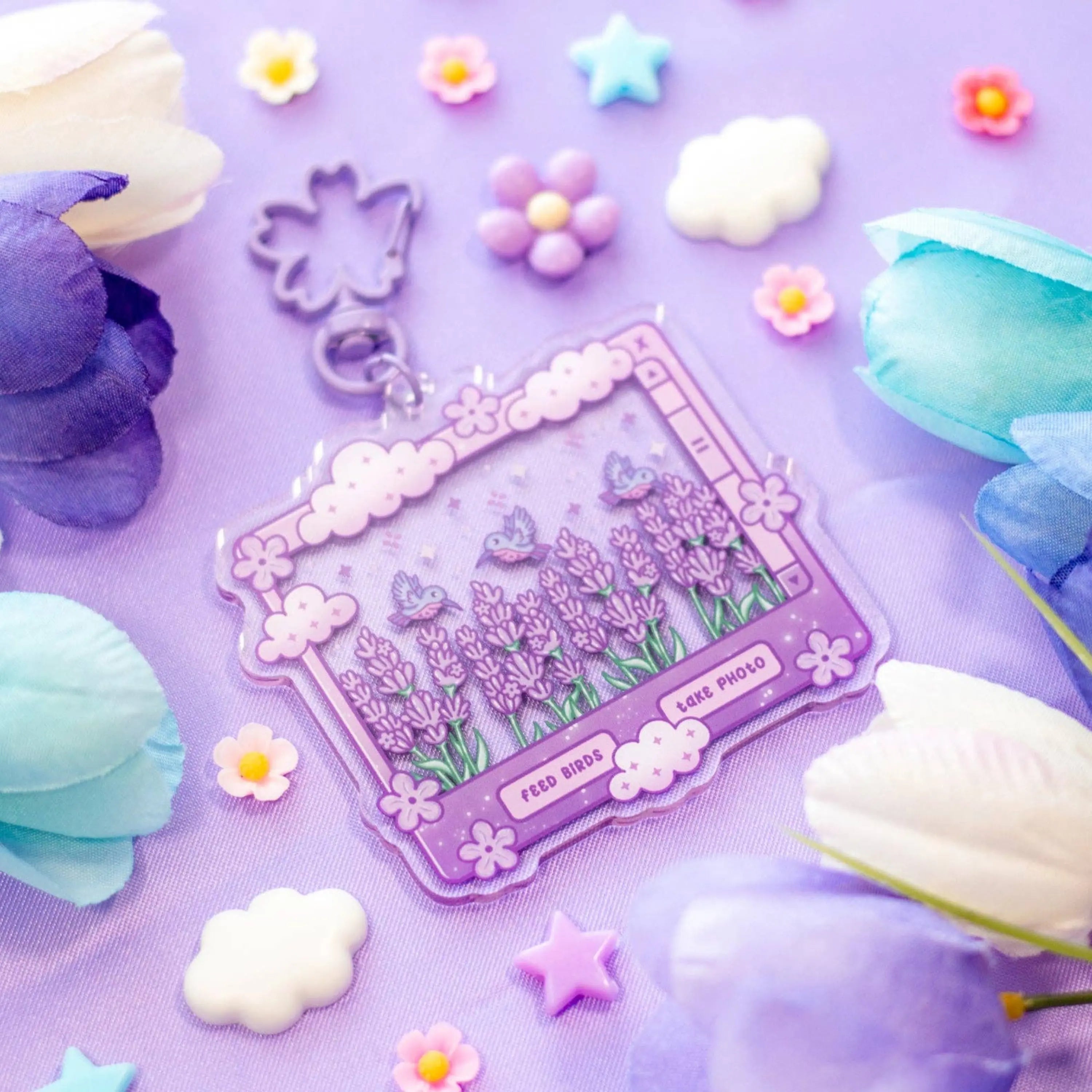 Decorative keychain with floral design on a purple background with flowers and clouds.