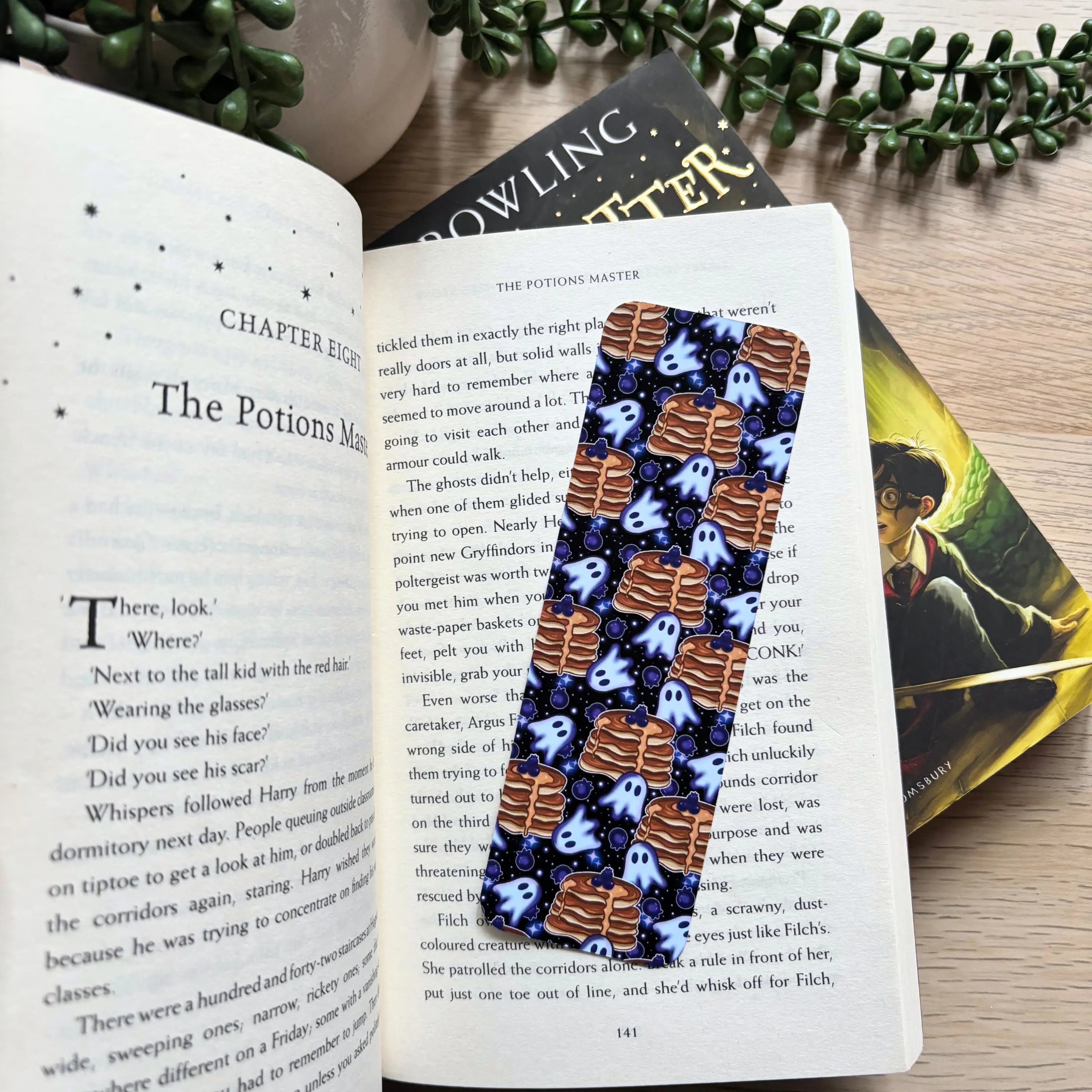 Cute ghost pancakes pattern on a rectangular fabric bookmark with rounded corners placed in an open book.