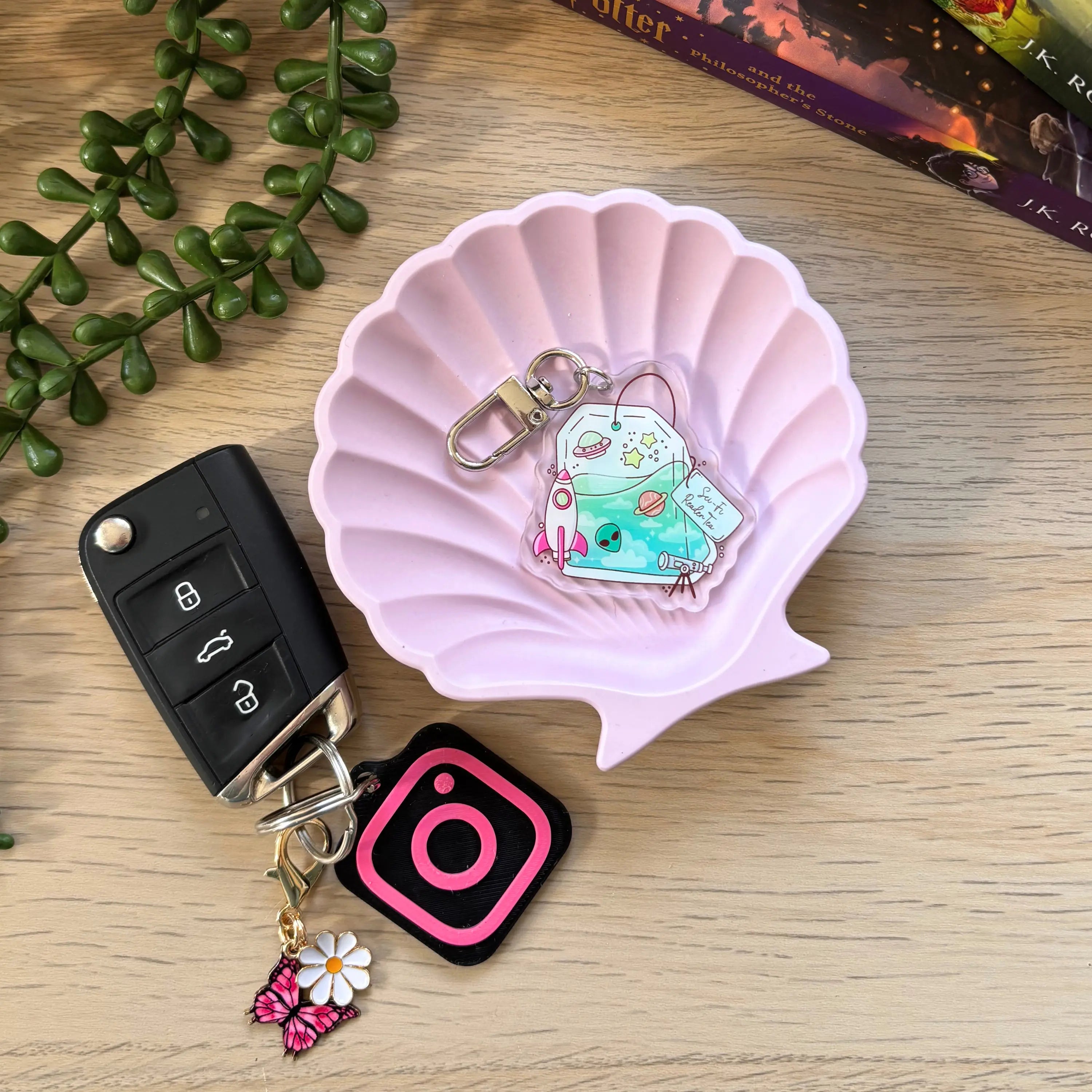 Colorful acrylic keyring featuring a cute robot reading a book, attached to a silver key clip.