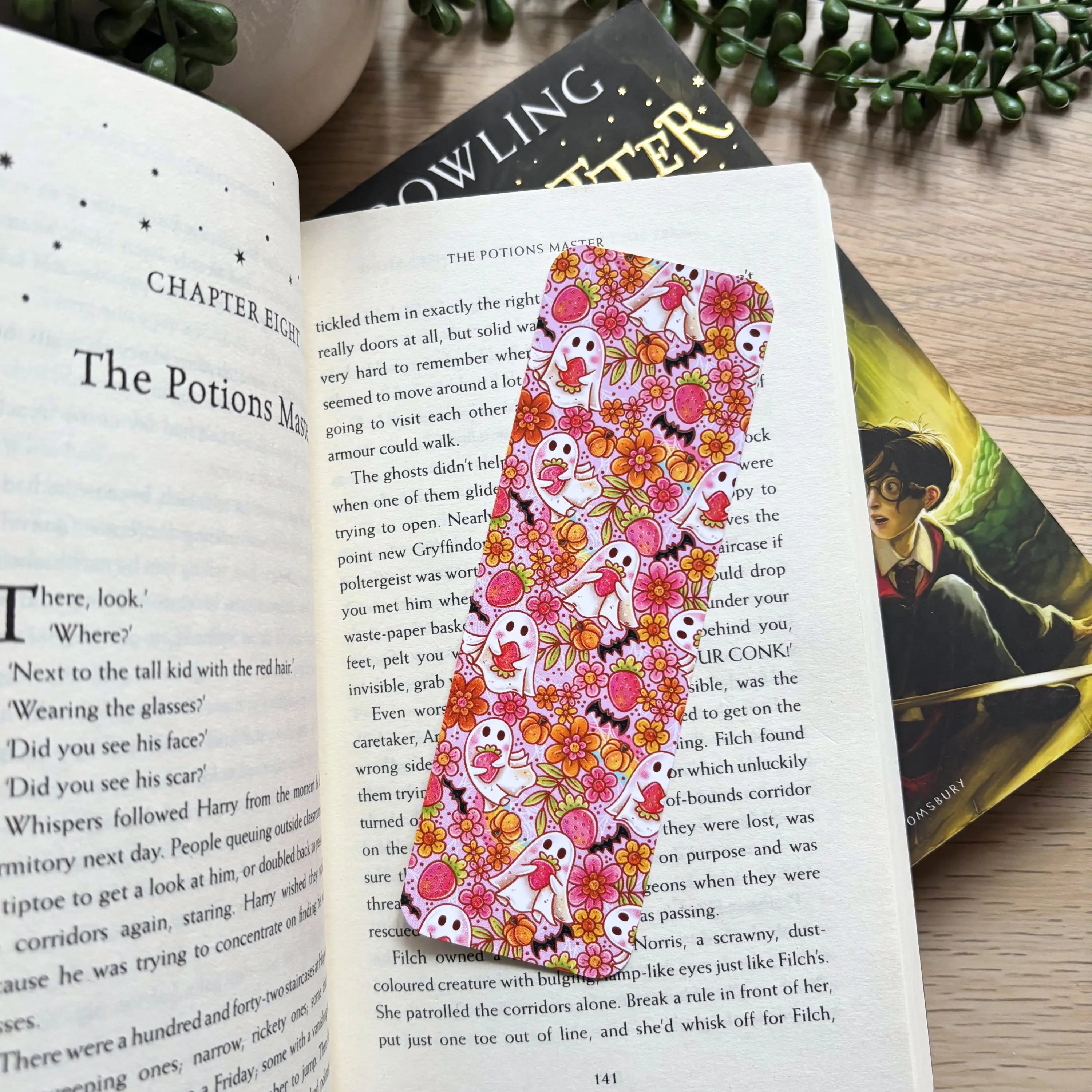 Pink Halloween-themed bookmark with cute strawberry ghosts, skulls, and floral accents.