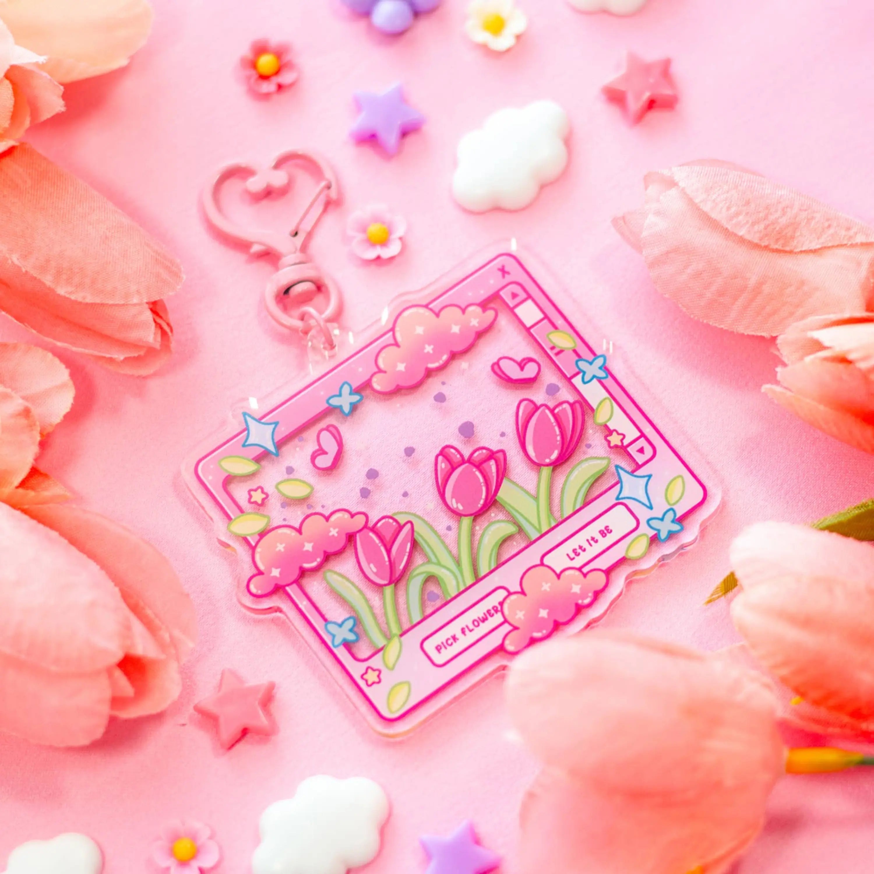Decorative keychain with floral design on a pink background with flowers and clouds.