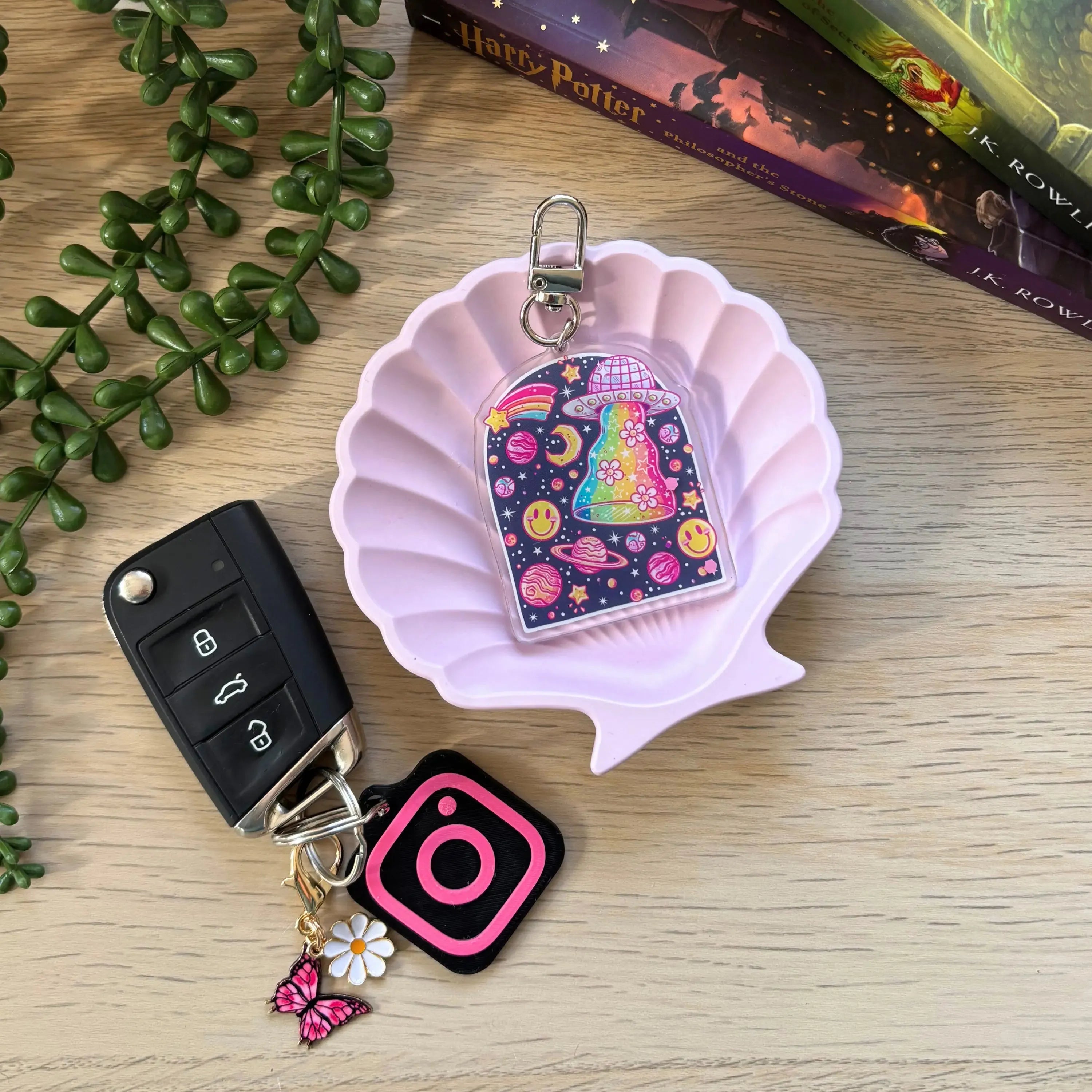 Colorful UFO keyring with whimsical alien and spaceship design on wooden surface.