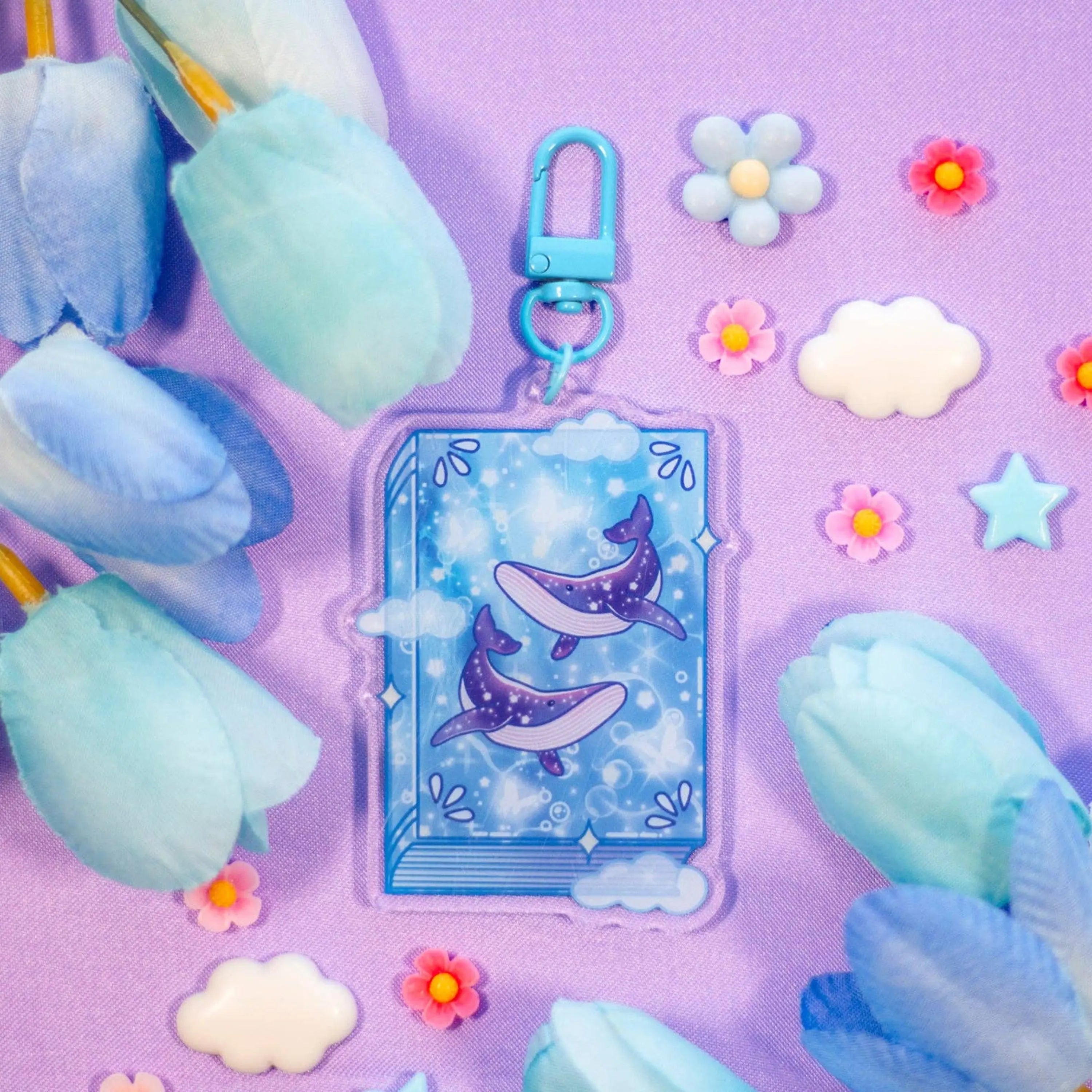 Cartoon keychain with whales on a purple background with cotton candy and flowers