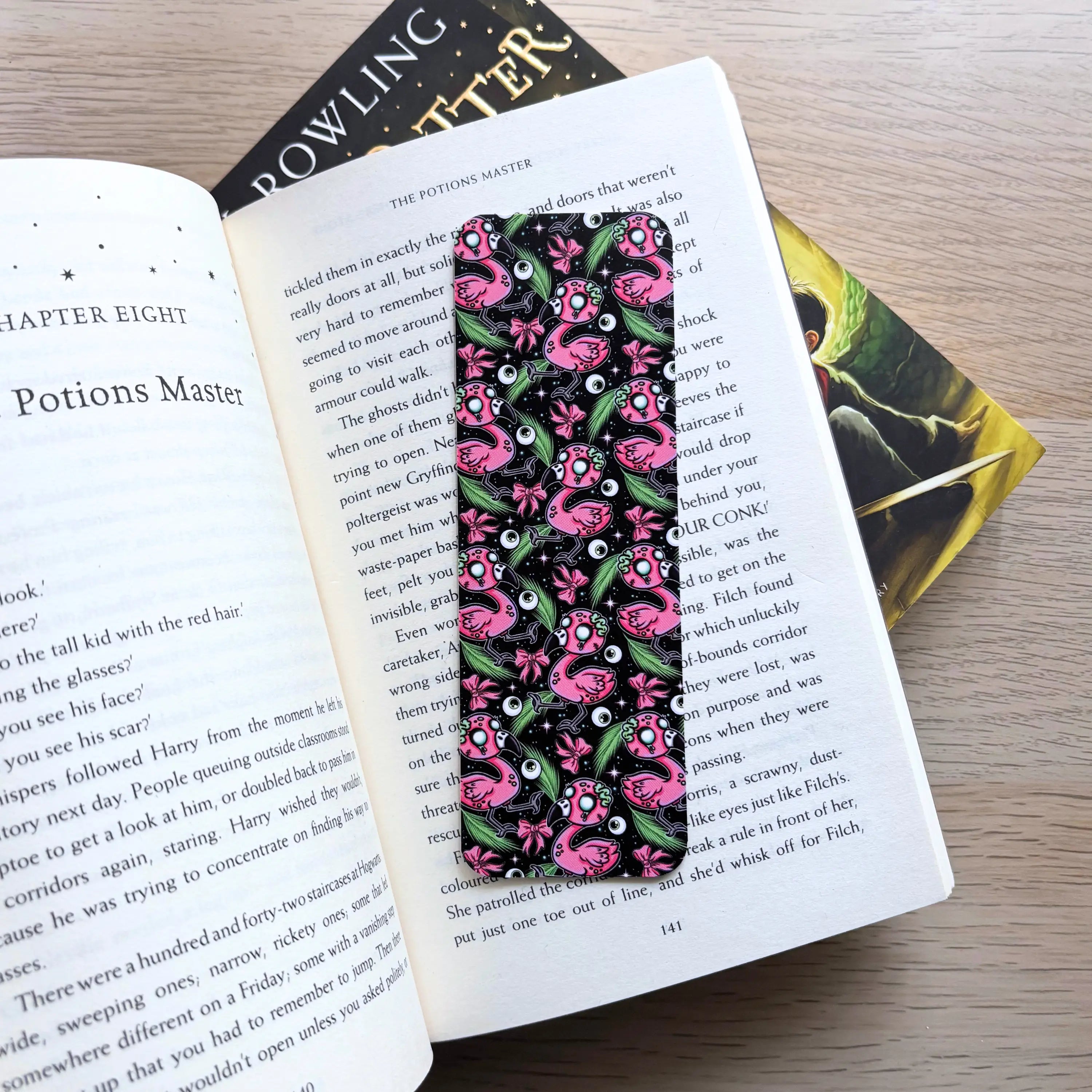 Black bookmark with pink zombie flamingo pattern featuring spooky tropical skulls and bones.